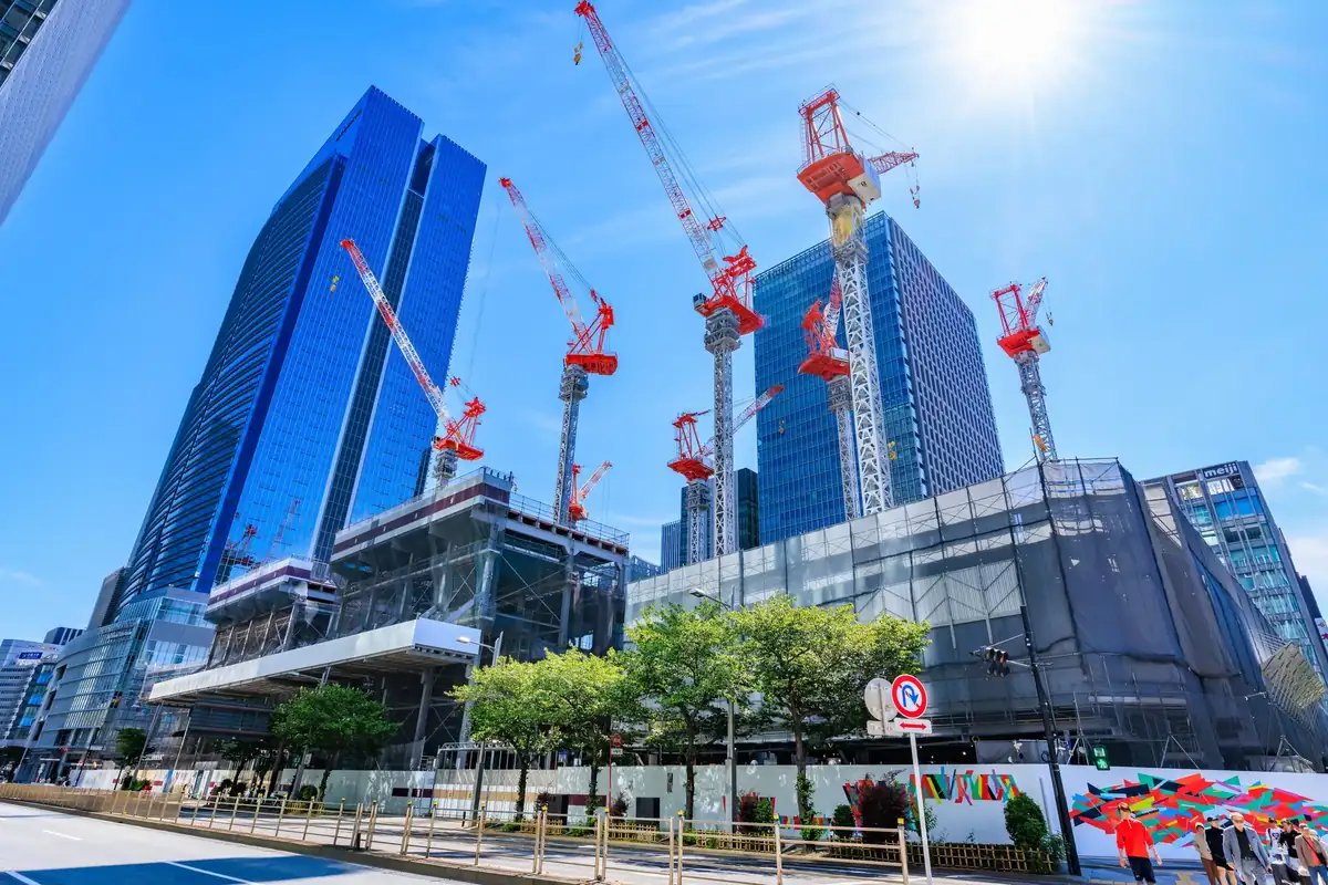 タワークレーンが立つ建設現場と建築中の建物